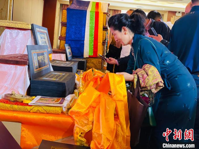 圖為現(xiàn)場藏族民眾向黃金書寫的大藏經(jīng)《甘珠爾》敬獻(xiàn)哈達(dá)?！O睿 攝