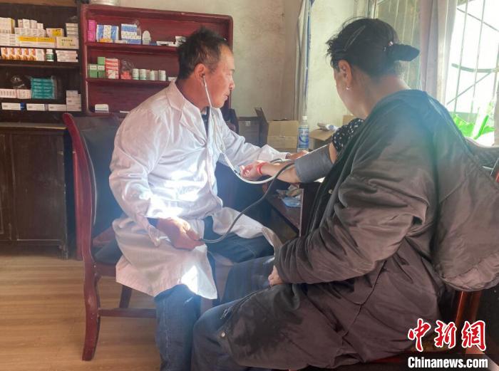 索木滾(左)為村民看病?！∪捞量h委宣傳部供圖