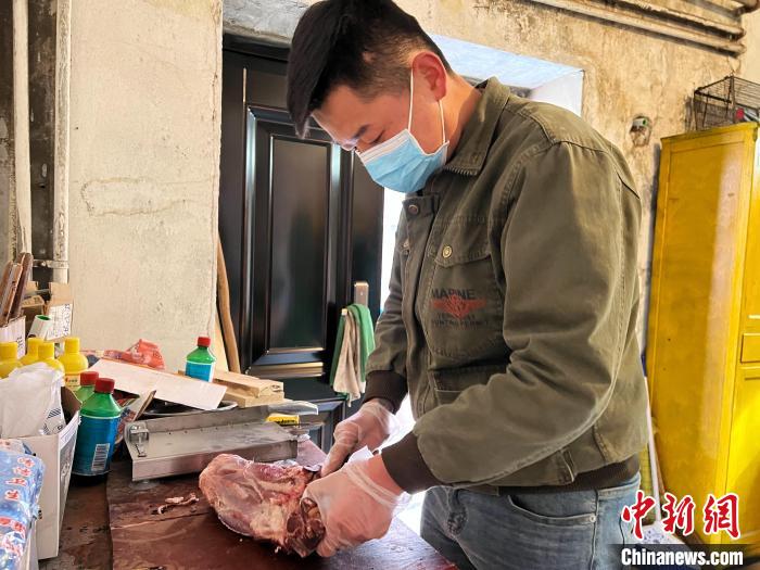 圖為雪豹“奶爸”史壽軍正在準(zhǔn)備投喂雪豹的食材?！●R銘言 攝