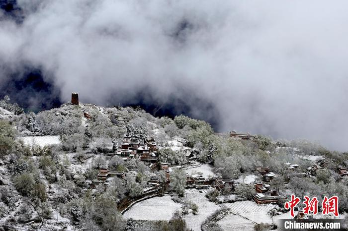 雪后的藏寨和碉樓構成美麗的雪景?！〗党鯘衫?攝