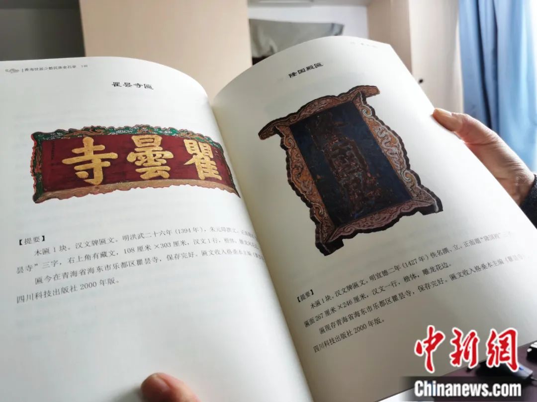 古籍保護(hù)人員展示介紹明代朱元璋撰寫的青海瞿曇寺匾(左)的出版書籍。張?zhí)砀?攝