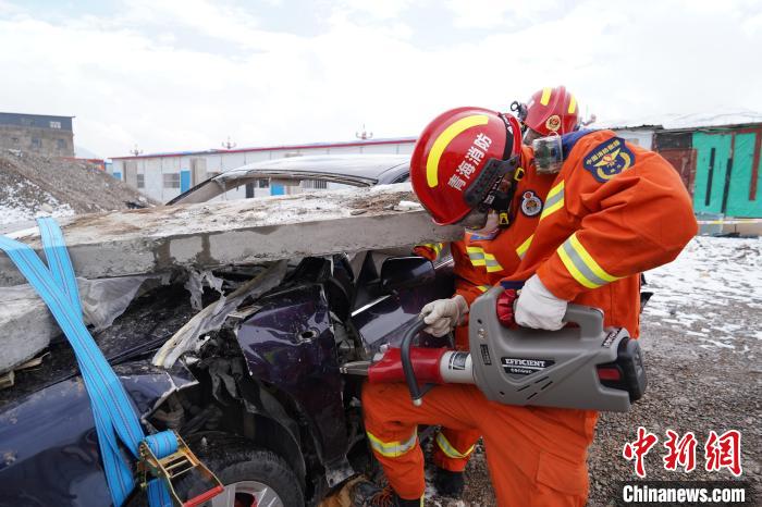 圖為地震實(shí)戰(zhàn)拉動現(xiàn)場，參演人員進(jìn)行車輛破拆?！∮駱湎拦﹫D