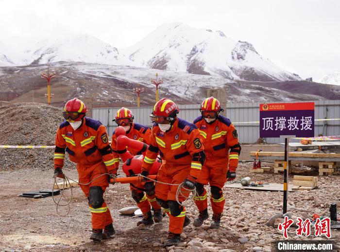 圖為地震實(shí)戰(zhàn)拉動現(xiàn)場，參演人員正在轉(zhuǎn)移受傷人員?！∮駱湎拦﹫D