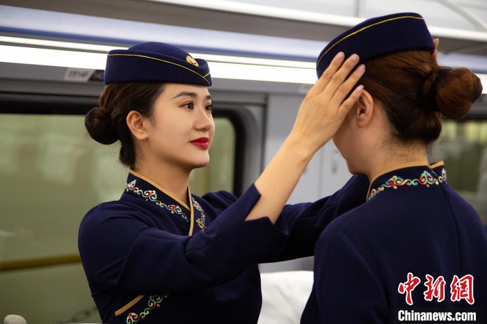 圖為青藏鐵路西格段“復興號”動車組乘務員互相整理新制服?！±罾?攝