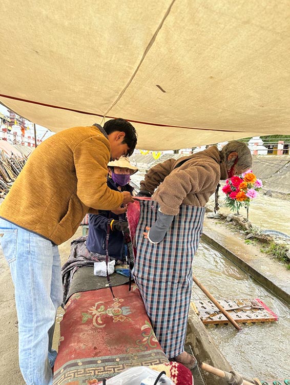 扎西奪爾登為路邊老人送去保暖圍腰。阿壩州文明辦供圖