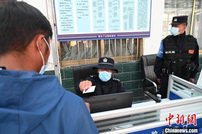 圖為移民管理警察登記完身份信息后將證件歸還給行人。　趙朗 攝