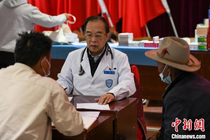 北京大學人民醫(yī)院心臟中心副主任、博士生導師王偉民為農牧民問診。　江飛波 攝