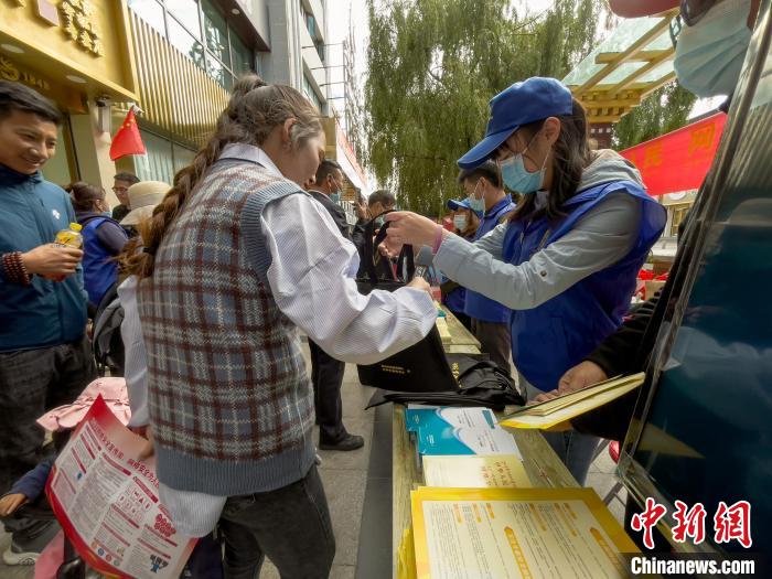圖為志愿者為市民發(fā)放網(wǎng)絡(luò)安全宣傳手冊(cè)?！≈x牧 攝