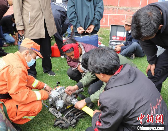 圖為森林消防員為護林員講解滅火裝備的使用方法?！〔际猩窒乐ш?供圖