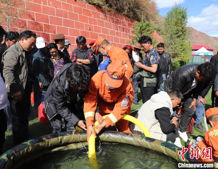 圖為森林消防員為護林員講解滅火裝備的使用方法?！〔际猩窒乐ш?供圖