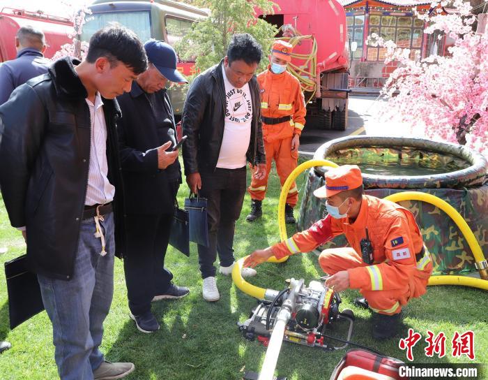 圖為森林消防員為護林員講解滅火裝備的使用方法?！〔际猩窒乐ш?供圖