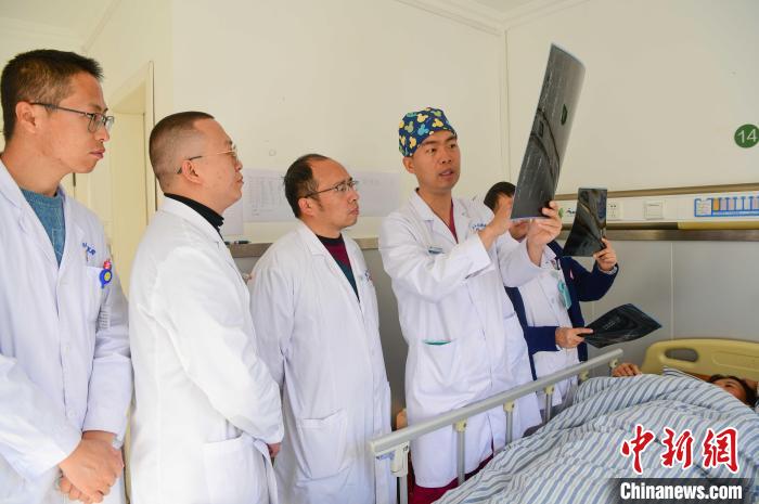 圖為何蔚副主任醫(yī)師(站右二)及團隊討論患者病情?！∝暩聛硭?攝
