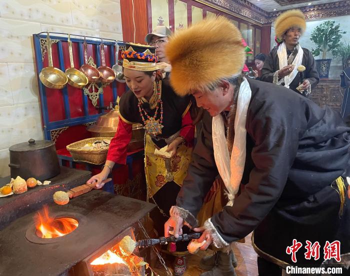 圖為人們?cè)诨鹕峡竟?jié)日美食“結(jié)達(dá)”?！∪轿木?攝