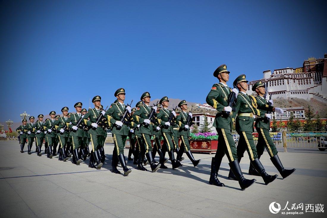 國(guó)旗護(hù)衛(wèi)隊(duì)隊(duì)員緊握鋼槍，踏著威武雄壯的步伐，走向國(guó)旗臺(tái)。人民網(wǎng) 次仁羅布攝
