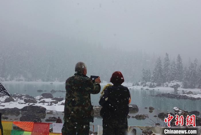 游客欣賞雪中然烏湖。　冉文娟 攝