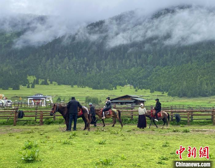 6月10日，游客在魯朗小鎮(zhèn)高山牧場景區(qū)體驗騎馬?！∪轿木?攝