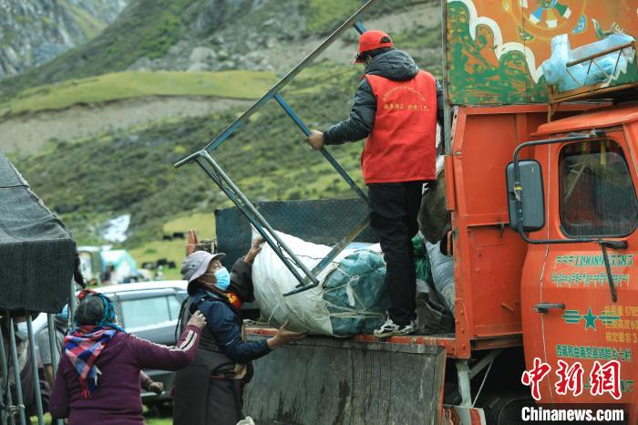 圖為工作人員幫助牧民們卸家具?！÷蹇?攝