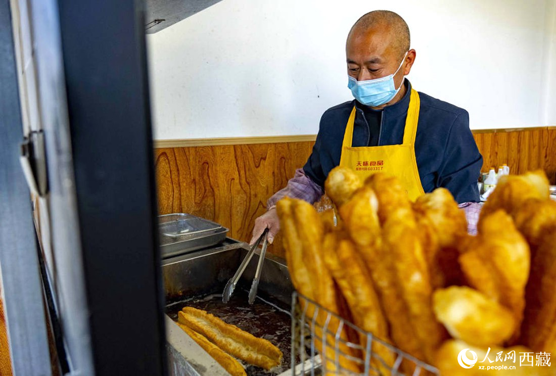 早餐店老板正在炸油條。人民網(wǎng) 次仁羅布攝