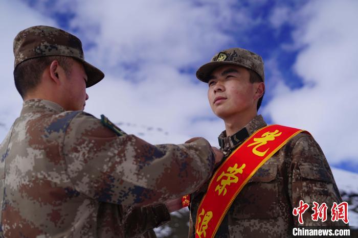 排長王朝偉(圖左)給退伍老兵佩戴大紅花?！∥鞑厣侥宪姺謪^(qū)某團供圖