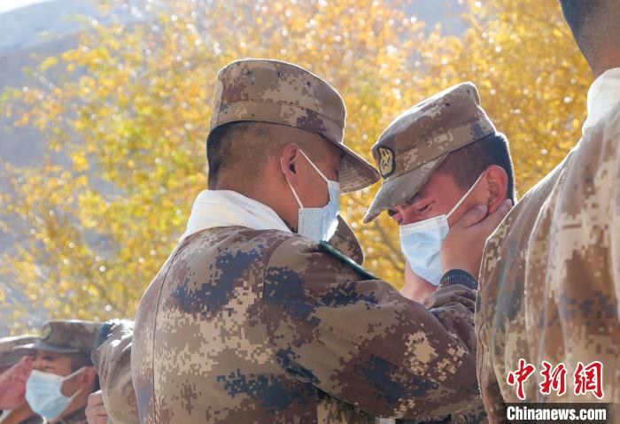 圖為什布奇邊防連退伍老兵與戰(zhàn)友相擁而泣，依依惜別?！⌒觳?攝