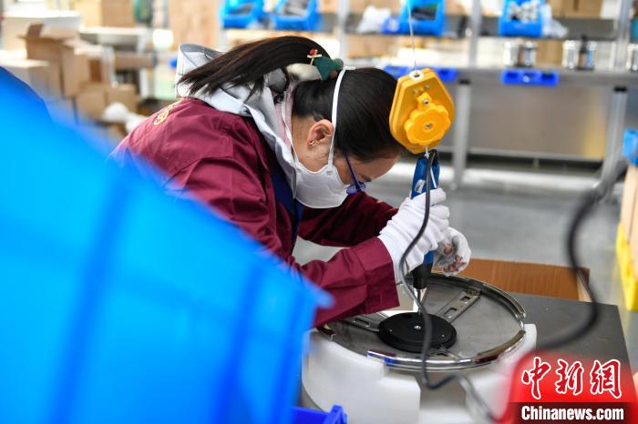 圖為工人正在組裝炊具?！∝暩聛硭?攝