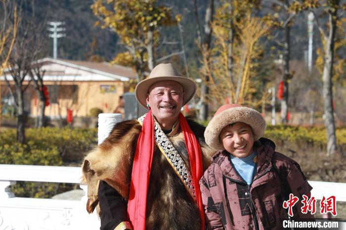 圖為林芝市巴宜區(qū)布久鄉(xiāng)仲果村村民桑杰與孫子一起參加藏歷新年活動?！埩?攝