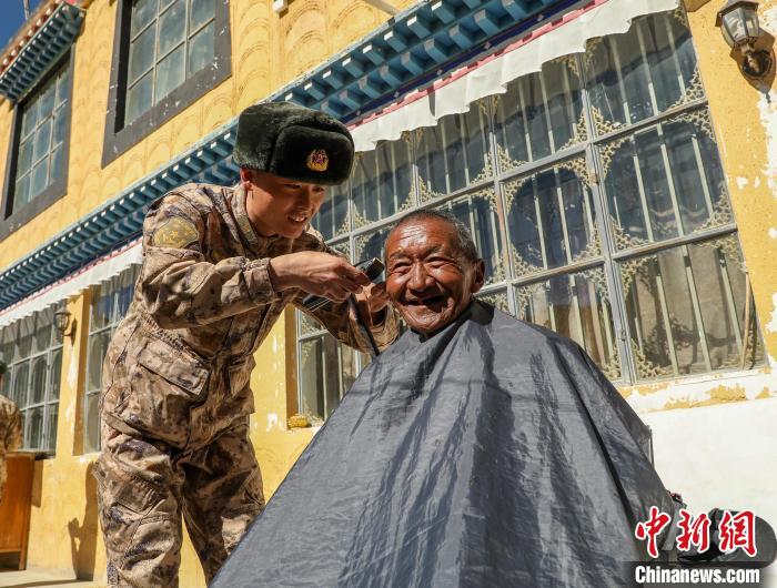 圖為阿里軍分區(qū)某邊防團官兵為駐地群眾理發(fā)迎藏歷新年?！〉┰鰝愔?攝