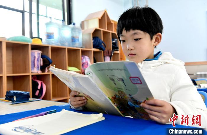 3月14日，西藏拉薩市第一小學(xué)一年級(jí)六班學(xué)生丁增樂(lè)吉在閱讀藏語(yǔ)課本?！±盍?攝