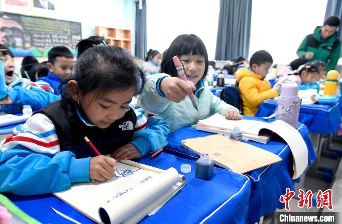 3月14日，西藏拉薩市第一小學(xué)一年級(jí)六班學(xué)生白瑪朗珍(圖左)在藏語(yǔ)文課上書(shū)寫(xiě)藏文。　李林 攝