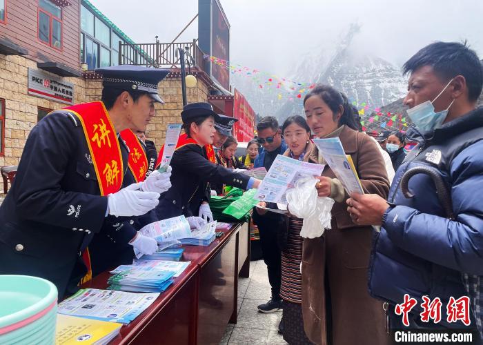 圖為山南玉麥邊境派出所民警為轄區(qū)群眾發(fā)放法律知識(shí)宣傳單?！＄婗?　攝