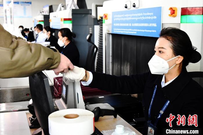 圖為機場工作人員為旅客辦理行李托運?！≈芎?攝