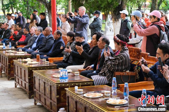 5月19日，中外嘉賓在羅布林卡和游客一起觀看藏戲。　江飛波 攝