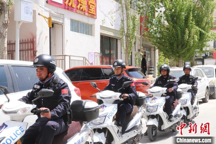 民警騎著電瓶車在轄區(qū)巡邏走訪。　黃創(chuàng)偉 攝