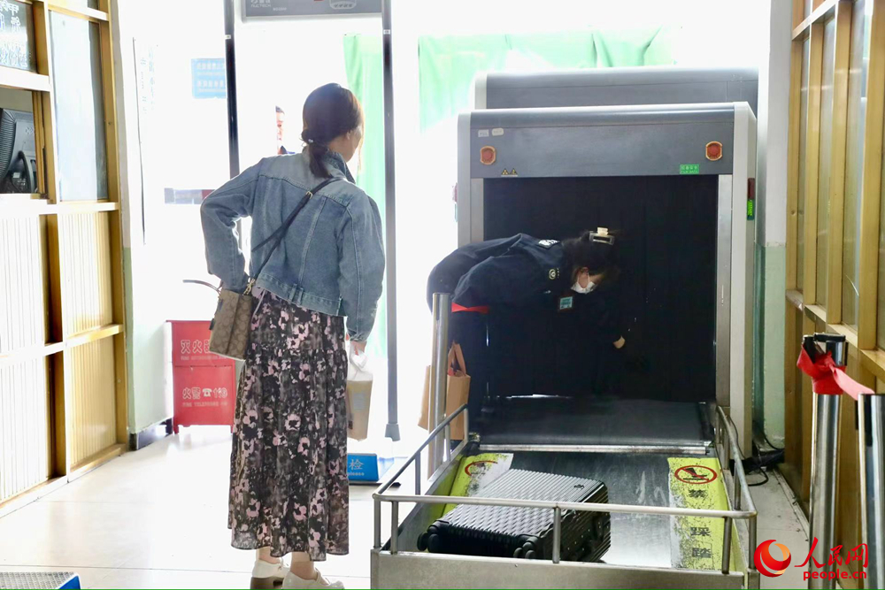 車站工作人員幫旅客提取行李。人民網(wǎng)記者 次仁羅布攝