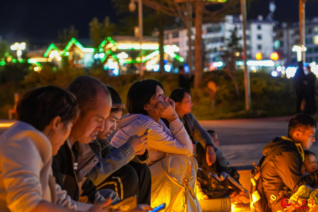 市民坐在西藏林芝市民族團(tuán)結(jié)廣場臺(tái)階上欣賞音樂噴泉。人民網(wǎng)記者 趙晨攝